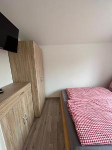 een kleine slaapkamer met een bed en een houten kast bij Eichkobel in Rheinsberg