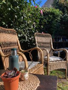two wicker chairs and a table with a water bottle at Rincón Colonial in Colonia del Sacramento