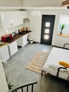 a room with a kitchen with a bed and a table at Tiny house 4 min drive to Cdg airport in Roissy-en-France