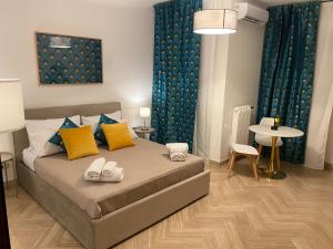 a bedroom with a bed with yellow and blue pillows at La Dimora dei Teatri, Luxury rooms in Palermo
