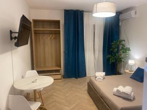 a small room with a bed and a table and a tv at La Dimora dei Teatri, Luxury rooms in Palermo