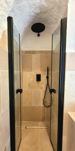 La salle de bains est pourvue d'une douche avec une porte en verre. dans l'établissement Trulli Respiro dei Venti, à Ostuni