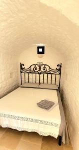ein Schlafzimmer mit einem Bett in einer weißen Wand in der Unterkunft Trulli Respiro dei Venti in Ostuni