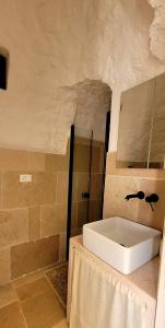 ein Bad mit einem Waschbecken im Zimmer in der Unterkunft Trulli Respiro dei Venti in Ostuni