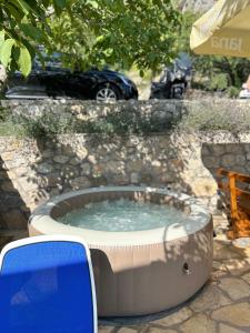 a hot tub in a yard with a car in the background at Stone house Marinko - Free Beach Parking in Tučepi