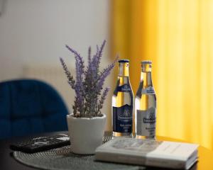 zwei Flaschen Wein auf einem Tisch mit einem Buch in der Unterkunft LOFT HOUSE APARTMENTS in Przemyśl