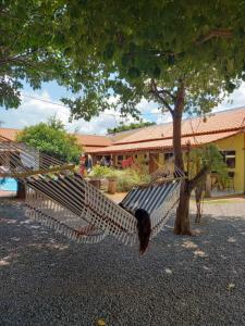 a hammock hanging from a tree in front of a building at Pousada Cantinho de Casa in Nobres
