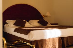 a bedroom with a large bed with a wooden headboard at Hotel Ara Solis in Lido Azzurro