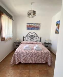 una camera da letto con un letto e due asciugamani di ADOSADO CON VISTAS, RELAJATE Y DISFRUTA ad Ayamonte
