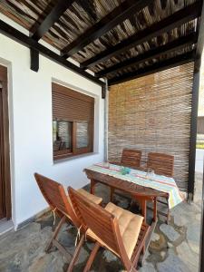 een patio met een houten tafel en stoelen bij Melro in Skiathos-stad