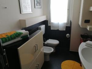 La salle de bains est pourvue de toilettes blanches et d'un lavabo. dans l'établissement Appartamento Angela, à Cento