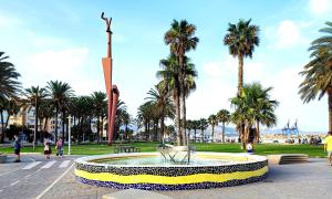 a fountain in the middle of a park with palm trees at Bright and quiet studio in Málaga in Málaga