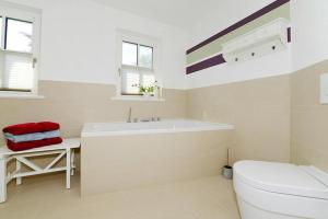 Un baño blanco con bañera y inodoro. en Ferienwohnung in Wyk auf Foehr, en Wyk auf Föhr 19 fotos más