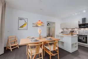 uma cozinha e sala de jantar com uma mesa de madeira e cadeiras em Altstadtbude 27 - modernes Apartment in historischer Altstadt em Rostock