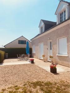 a house with a patio with a table and chairs at Fleur de lys, Nazelle-Négron in Nazelles