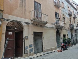 einem Roller, der vor einem Gebäude geparkt ist in der Unterkunft Tampasio Apartment Trapani centro in Trapani