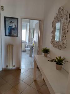 een woonkamer met een tafel en een spiegel bij Lacasadelmare in Francavilla al Mare