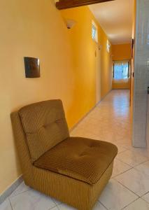 エルコラーノにあるB&B Vesuvius Homeの黄色の壁のリビングルーム(椅子付)