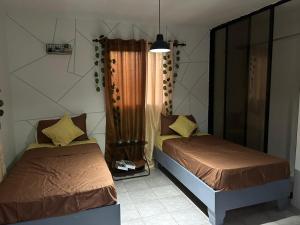 a bedroom with two beds and a window at Hotel Sol Azul in La Romana