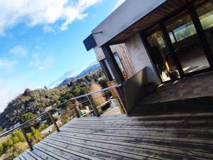 una escalera que conduce a una casa con montañas en el fondo en Los soles de montaña, en Villa Pehuenia
