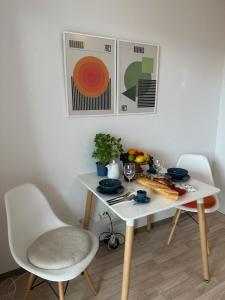 a white table and chairs with food on it at Stilvolles und modernes Appartement mit sonnigem Balkon in Flughafen- und Messenähe 31 in Leinfelden-Echterdingen