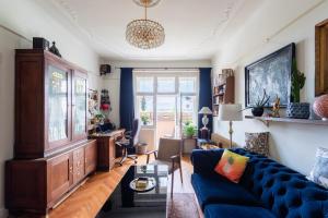 a living room with a blue couch and a desk at Victoria Design Stays - Premium Apartment Ohrada in Prague