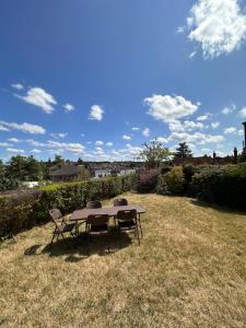 a table and two chairs in a field with a sky at Rochester town centre beautiful 3-Bedroom House with garden in Strood