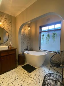 baño grande con bañera y ventana en Dolphin Circle Bed and Breakfast en Plettenberg Bay