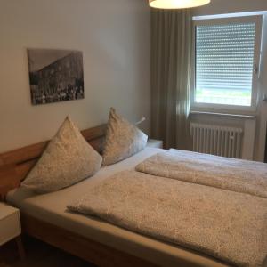 a bedroom with a bed with two pillows and a window at Ferienwohnung „Zur alten Brauerei“ in Mesenich