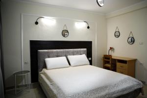 1 dormitorio con 1 cama con 2 almohadas en Martin Villa Gjirokaster, en Gjirokastra