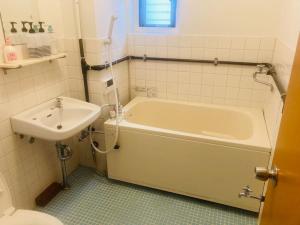 a bathroom with a tub and a sink at 渋谷駅徒歩6分!高速インターネット光回線 in Tokyo
