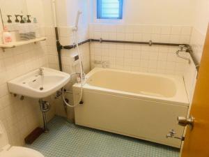 a bathroom with a white tub and a sink at 渋谷駅徒歩6分!高速インターネット光回線 in Tokyo