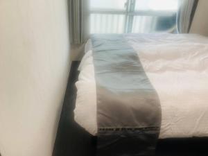 a bed sitting in a room with a window at 渋谷駅徒歩6分!高速インターネット光回線 in Tokyo