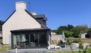 une maison blanche avec une véranda et une terrasse dans l'établissement Maison Pleubian mer à pied, à Pleubian