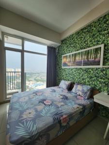 a bedroom with a bed with flowers on it at Troom treepark city apartement in Kebun Nanas