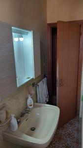 een badkamer met een witte wastafel en een spiegel bij Chi nnicchi e nnacchi in Noto