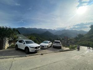 drei Autos, die am Straßenrand geparkt sind in der Unterkunft Sakura Homestay in Sa Pa