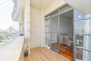um quarto vazio com uma cadeira e uma grande janela em Apartamento em ótima localização em São Paulo