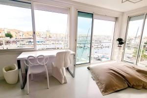 een slaapkamer met een bed, een bureau en ramen bij Le rêve de Déborah in Cap d'Agde +21 foto's