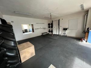 a large room with a white wall and a black floor at Tiny House Gänseblümchen in Kirchanschöring