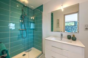 a bathroom with a shower and a sink and a mirror at Villa de standing mer, proximité plage et thalasso in Douarnenez