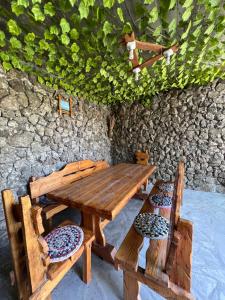 a wooden table and chairs with a stone wall at Dinadav house in Garni