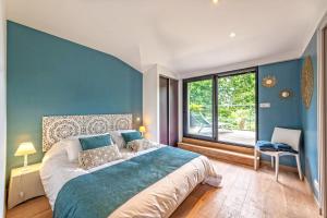 a bedroom with a large bed with a blue wall at Villa de standing mer, proximité plage et thalasso in Douarnenez