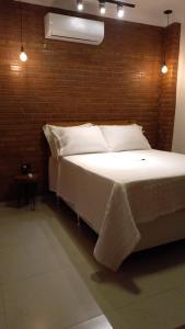 a large bed in a room with a brick wall at Pousada Bem Viver in Nobres