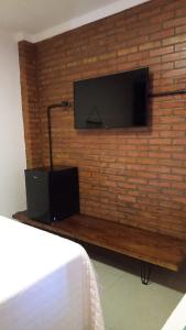 uma parede com uma televisão numa parede de tijolos em Pousada Bem Viver em Nobres
