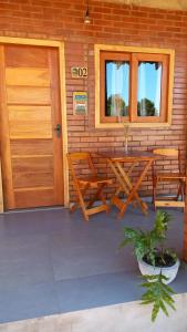 eine Terrasse mit einem Tisch, Stühlen und einer Tür in der Unterkunft Pousada Bem Viver in Nobres