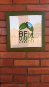a sign on a brick wall with a be a winner sign at Pousada Bem Viver in Nobres