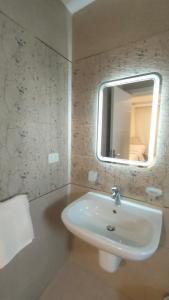 a bathroom with a white sink and a mirror at شقه 175 م للايجار كمباوند ستون ريزيدنس التجمع الخامس القاهره الجديده in Cairo