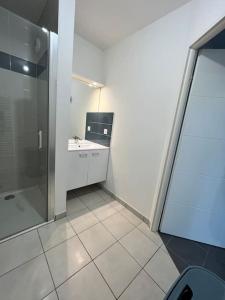 a white bathroom with a shower and a sink at Super appartement, la Guérinière à Noirmoutier in La Guérinière