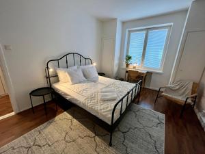 a bedroom with a bed with white sheets and a window at Hogland Apartments - 3 in Kotka